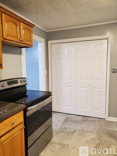 A kitchen with wooden cabinets and a black stove top oven.
