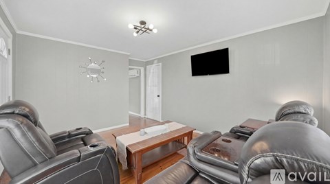 A living room with grey leather sofas and a wooden coffee table.