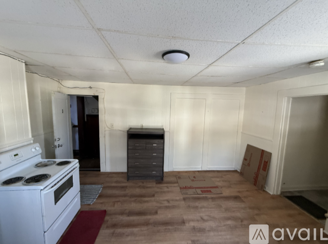 A kitchen with a white stove and a brown floor.