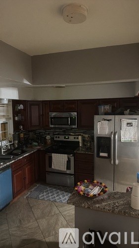 A kitchen with a refrigerator, oven, and microwave.