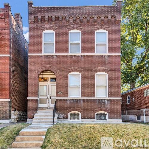 A red brick building with a white door and windows.