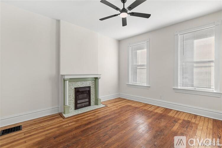A room with a fireplace and a ceiling fan.