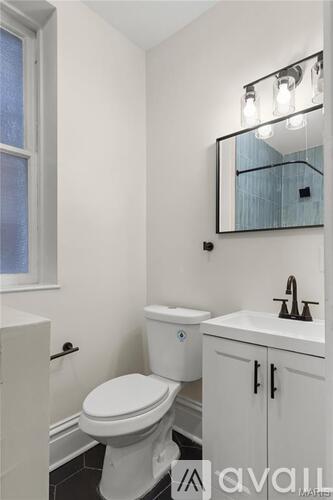 A white toilet sits next to a sink in a small bathroom.