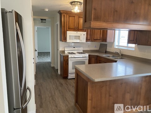 A kitchen with wooden cabinets and a refrigerator.
