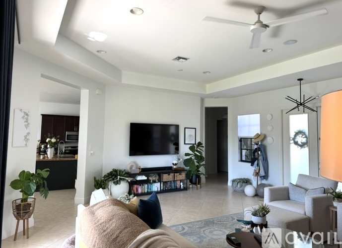 A living room with a large couch and a flat screen TV mounted on the wall.