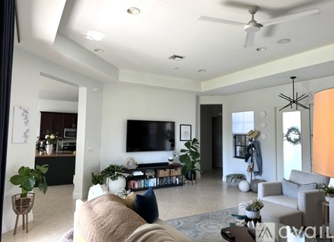 A living room with a large couch and a flat screen TV mounted on the wall.