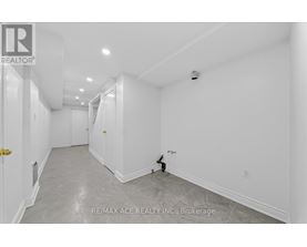 A spacious, empty room with a door on the left and a wall socket on the right.