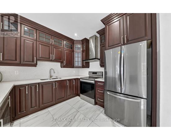 A kitchen with brown cabinets and a stainless steel refrigerator.