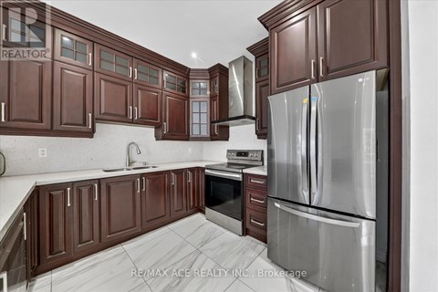 A kitchen with brown cabinets and a stainless steel refrigerator.