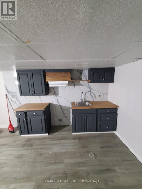 A kitchen with a white wall and a wooden counter top.