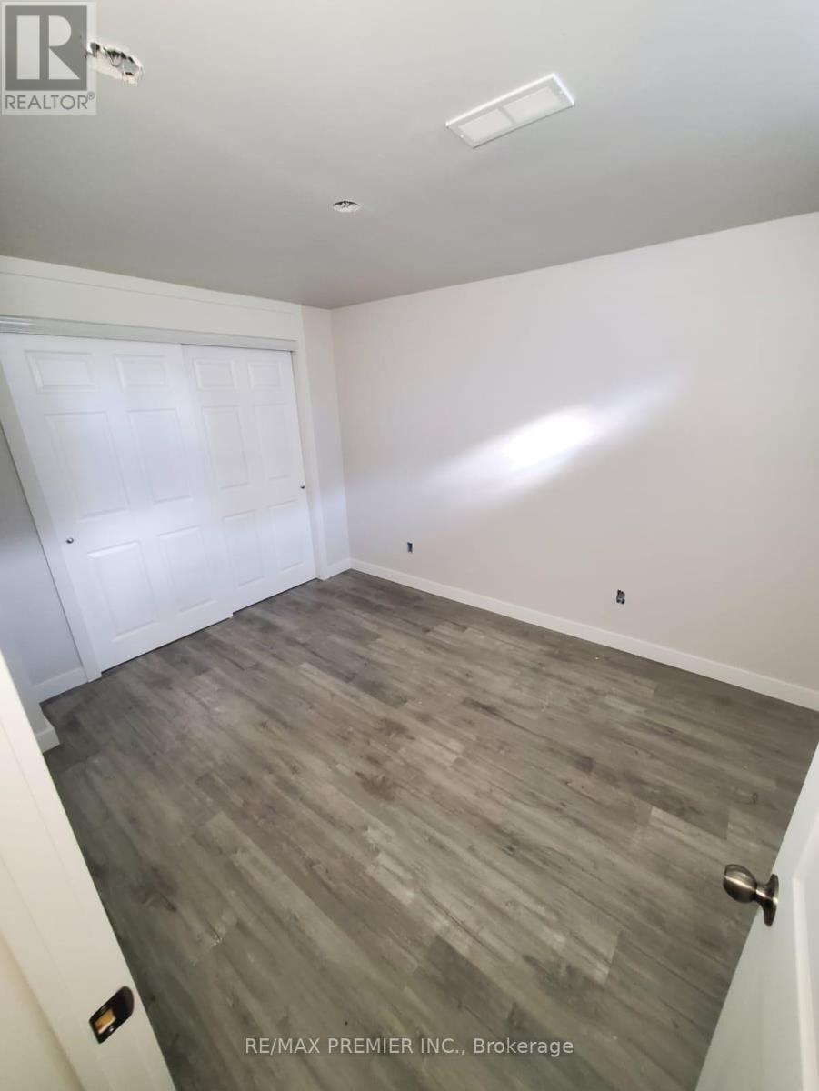 A room with a white door and a grey floor.