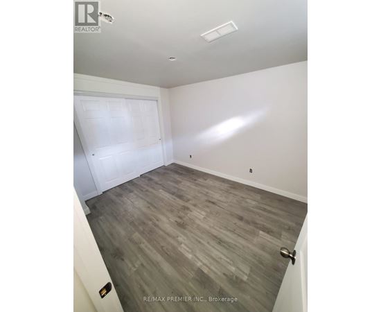 A room with a white door and a grey floor.