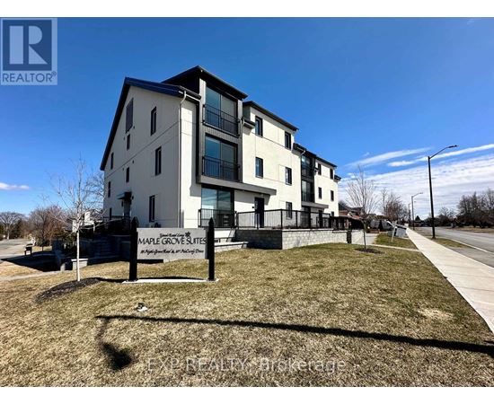 Maple Grove Suites is a modern apartment complex with a well-maintained lawn and a clear blue sky overhead.