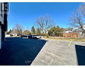 A parking lot with a few cars and trees in the background.