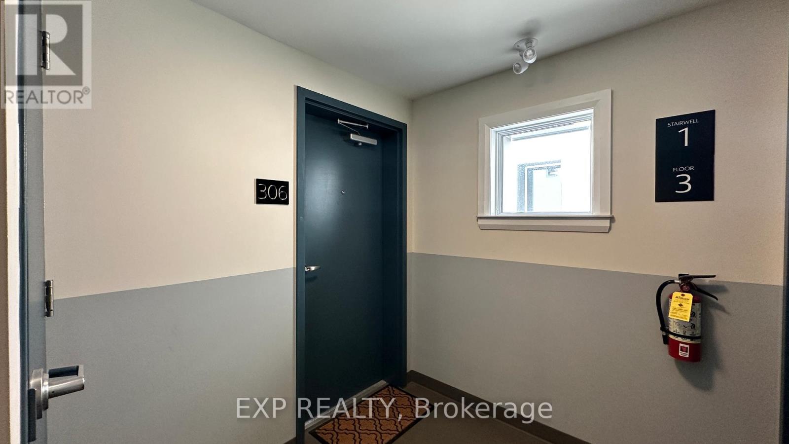 A brokerage office with a door labeled 200 and a fire extinguisher on the wall.