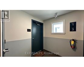 A brokerage office with a door labeled 200 and a fire extinguisher on the wall.