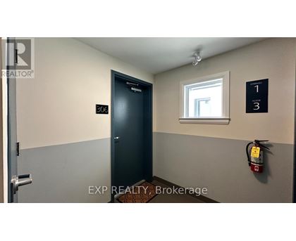 A brokerage office with a door labeled 200 and a fire extinguisher on the wall.