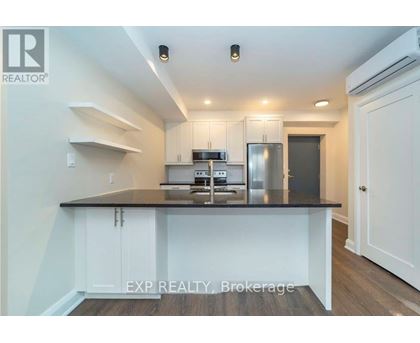 A kitchen with white cabinets and a black countertop.