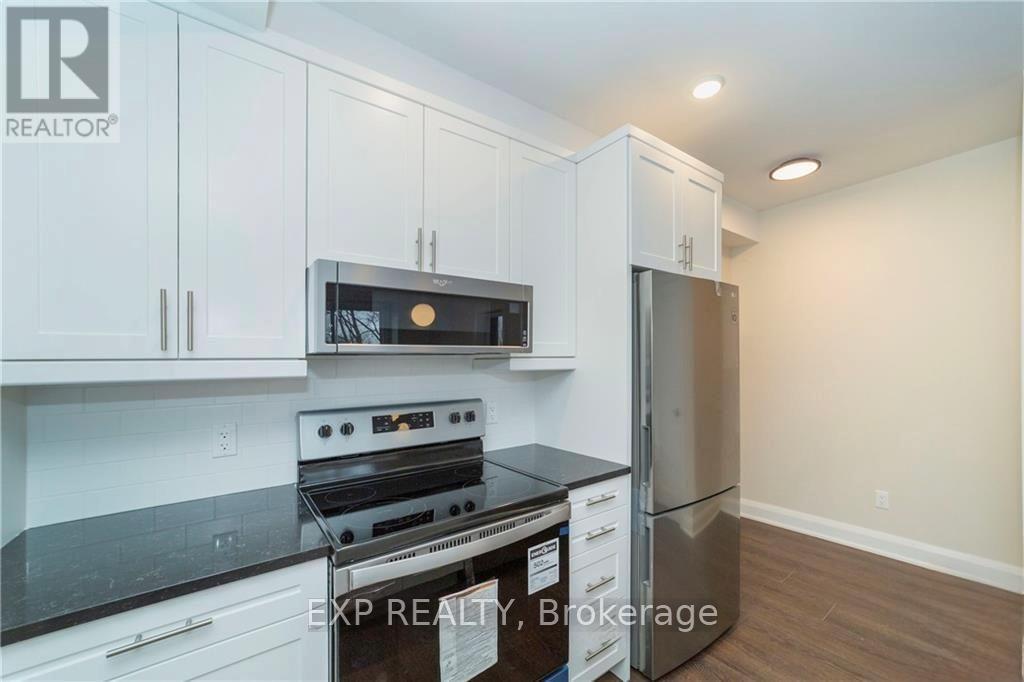 A kitchen with white cabinets and a black stove top oven.