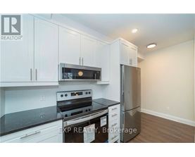 A kitchen with white cabinets and a black stove top oven.
