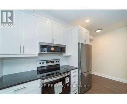 A kitchen with white cabinets and a black stove top oven.