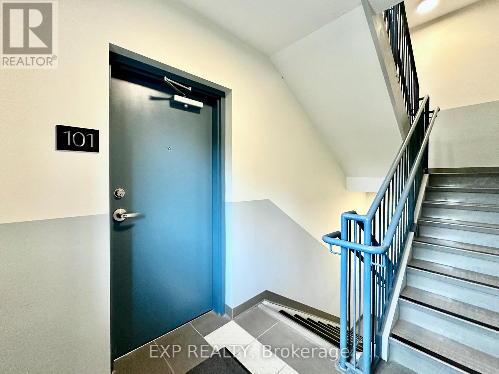 A blue door is at the end of a flight of stairs.
