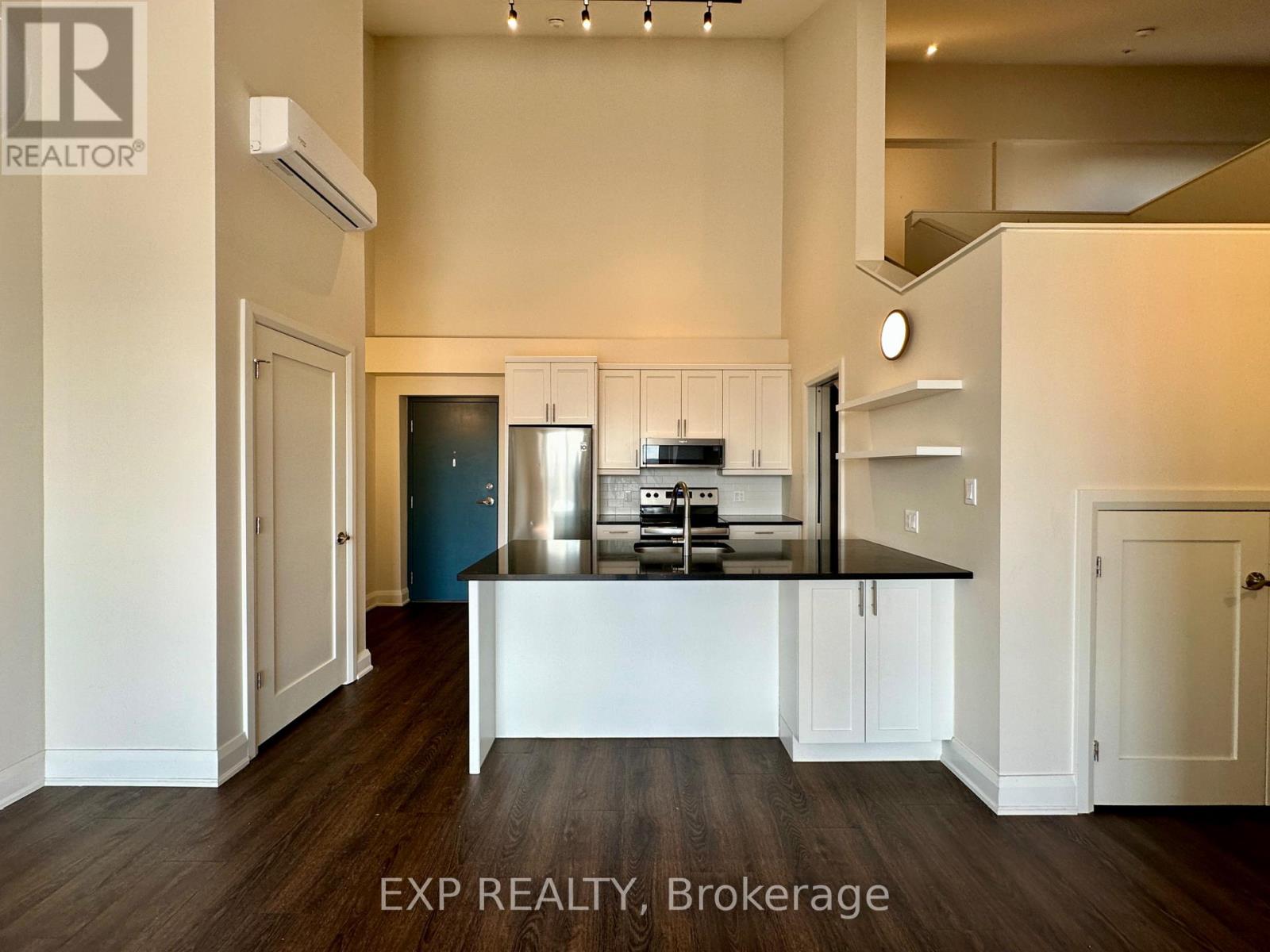 A kitchen with white cabinets and a black countertop.