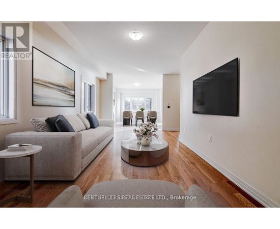 A living room with a grey couch, a coffee table, and a large painting on the wall.