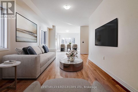 A living room with a grey couch, a coffee table, and a large painting on the wall.