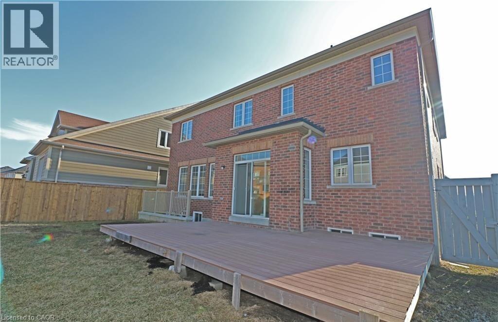 A red brick house with a wooden deck in front.