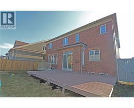 A red brick house with a wooden deck in front.