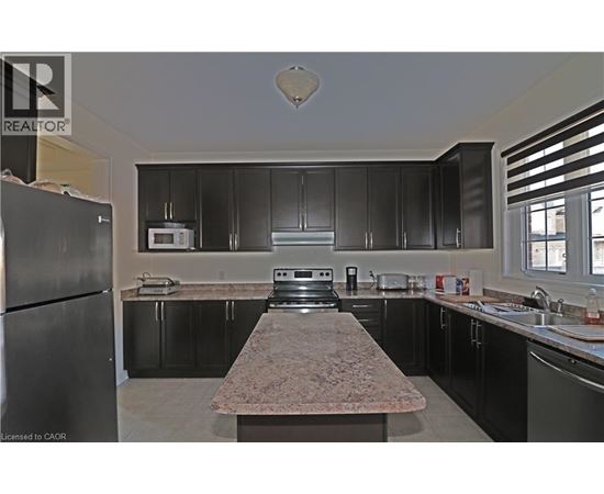 A kitchen with black cabinets and granite countertops.