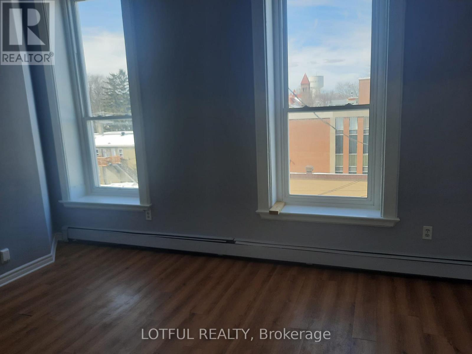 A room with a window showing a view of a building outside.