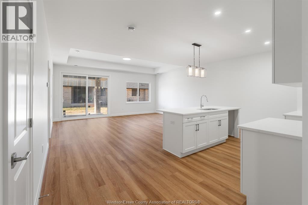 A kitchen with white cabinets and a wooden floor.