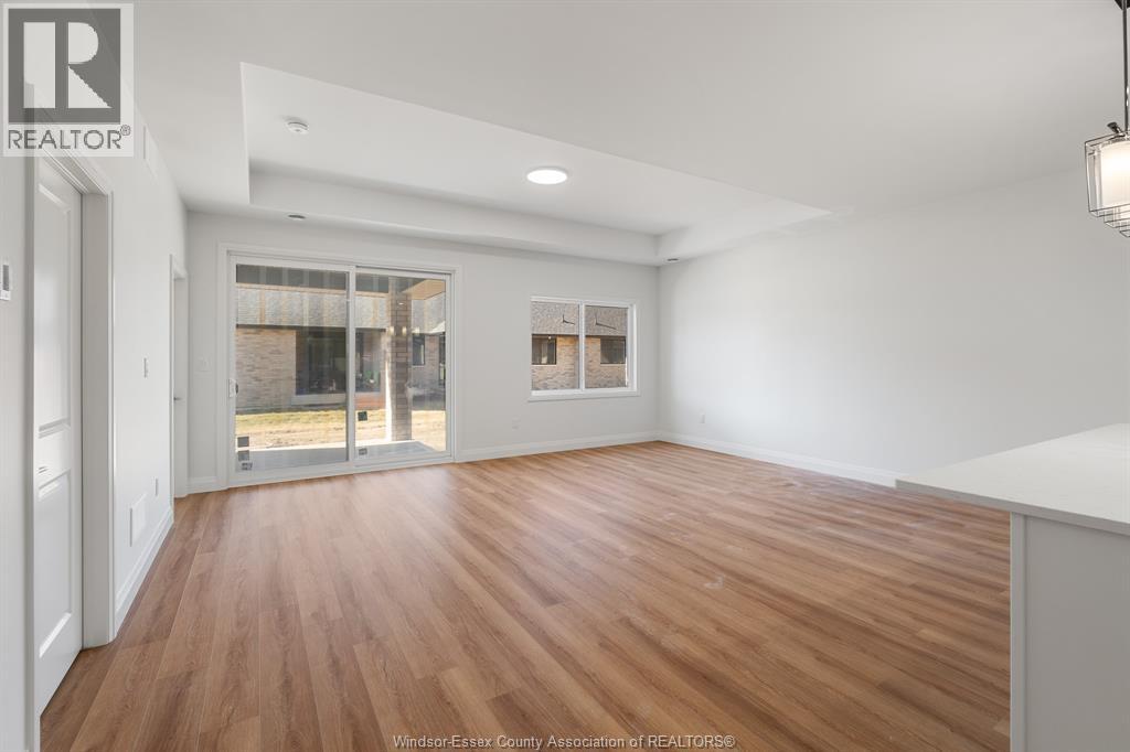 A spacious room with wooden flooring and white walls.