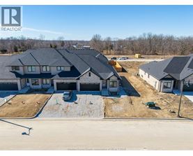 A real estate photo of a house with a car parked in front.