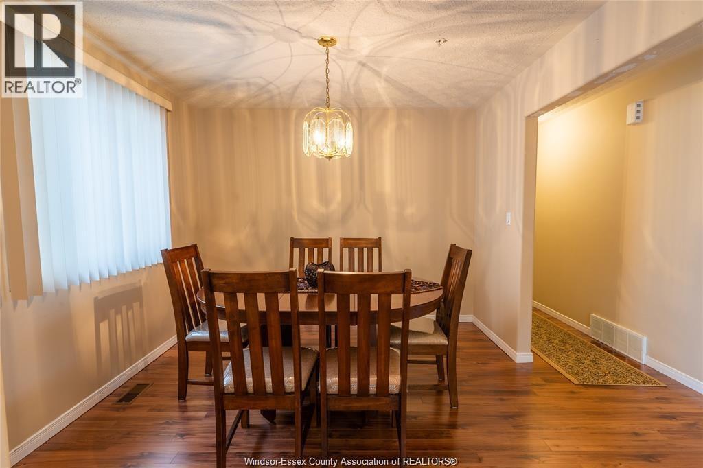 A dining room with a wooden table and chairs.