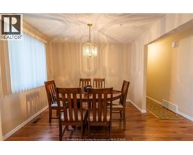 A dining room with a wooden table and chairs.