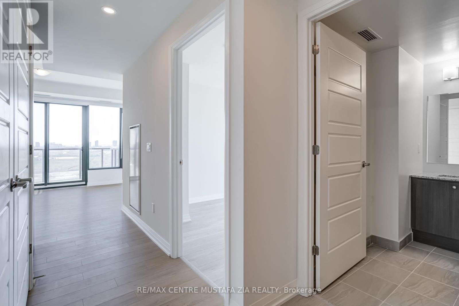 A white door is open to a hallway with a tiled floor.