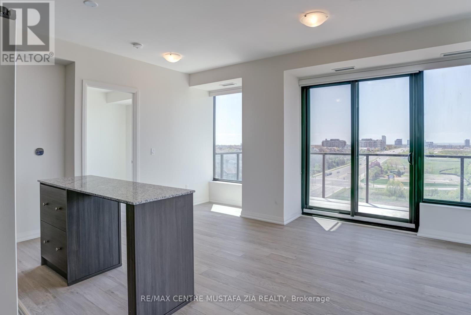 A spacious room with a desk and a view of the city through the windows.