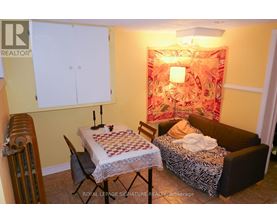 A room with a bed, a chair, a table, and a cabinet.
