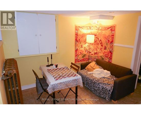 A room with a bed, a chair, a table, and a cabinet.