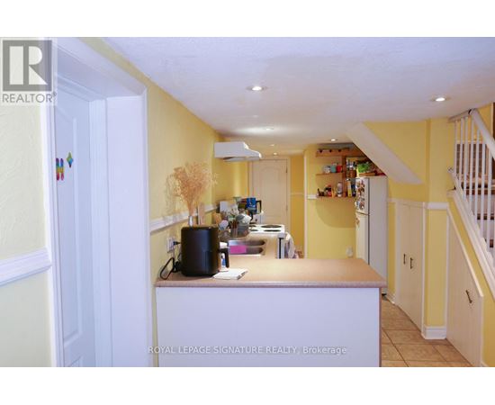 A kitchen with yellow walls and white cabinets.