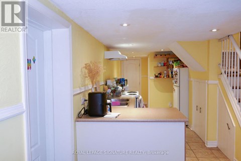 A kitchen with yellow walls and white cabinets.