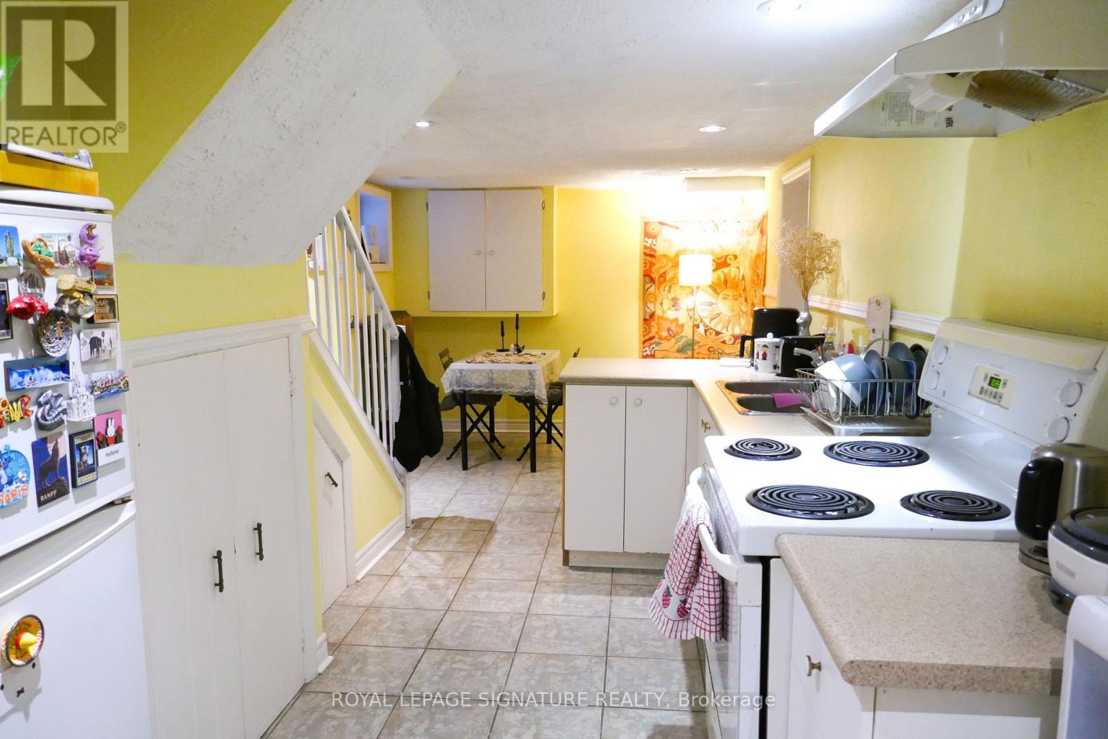 A kitchen with yellow walls and white appliances.