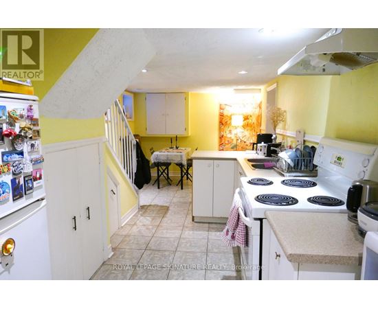A kitchen with yellow walls and white appliances.
