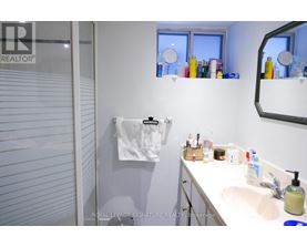 A white bathroom with a white sink and a white towel hanging on the wall.