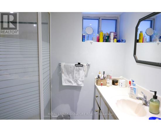 A white bathroom with a white sink and a white towel hanging on the wall.
