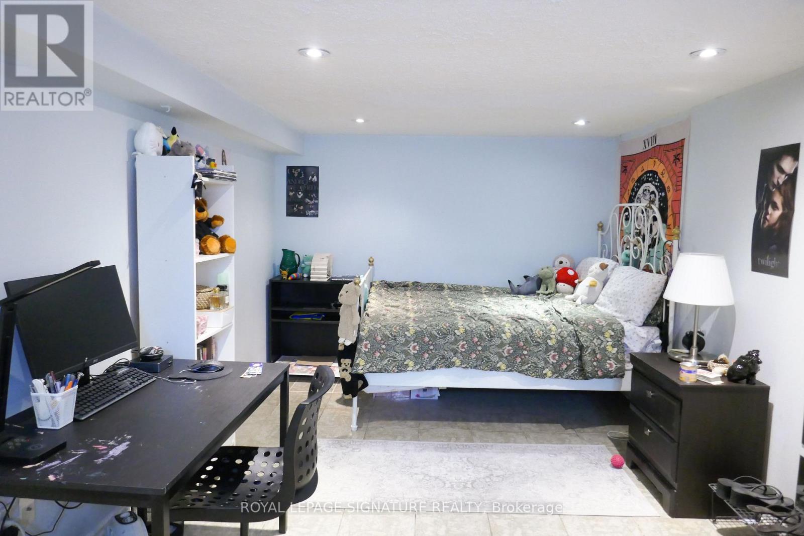 A bedroom with a bed, desk, and chair.