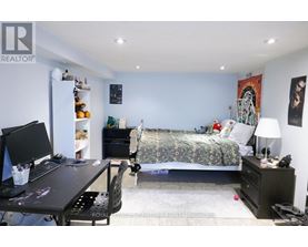 A bedroom with a bed, desk, and chair.